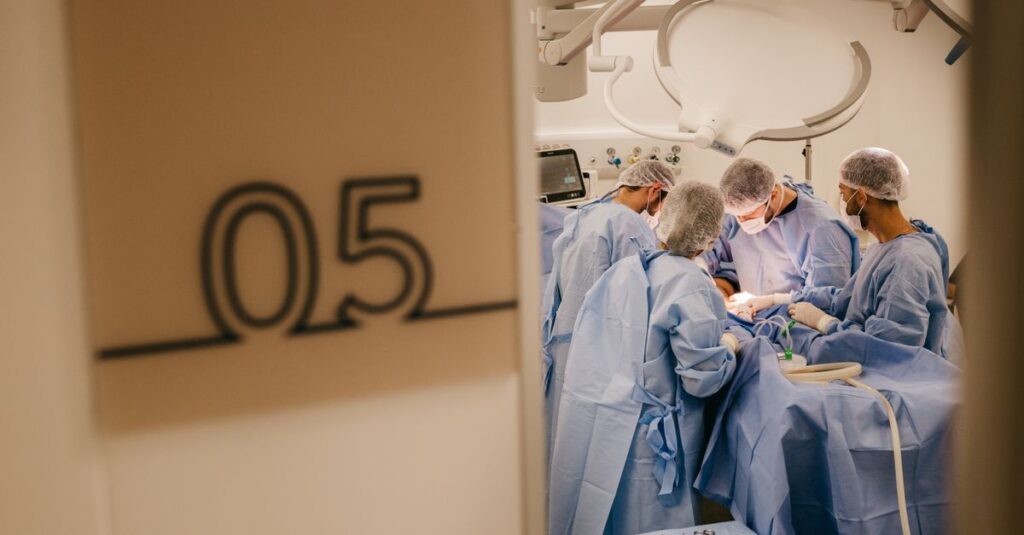 A group of surgeons operates in a hospital's sterile environment, focusing on a complex procedure.