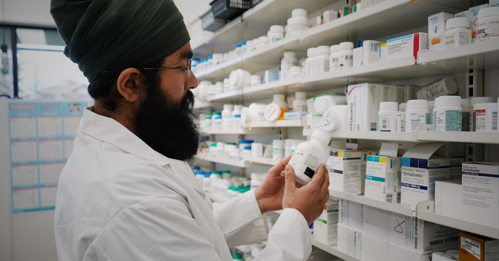 Pharmacist with turban organizing shelves in a pharmacy, focused on healthcare.