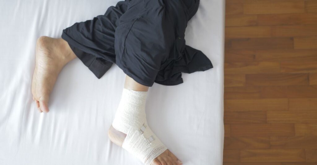 Top view of a bandaged foot resting on a bed, depicting injury and recovery.