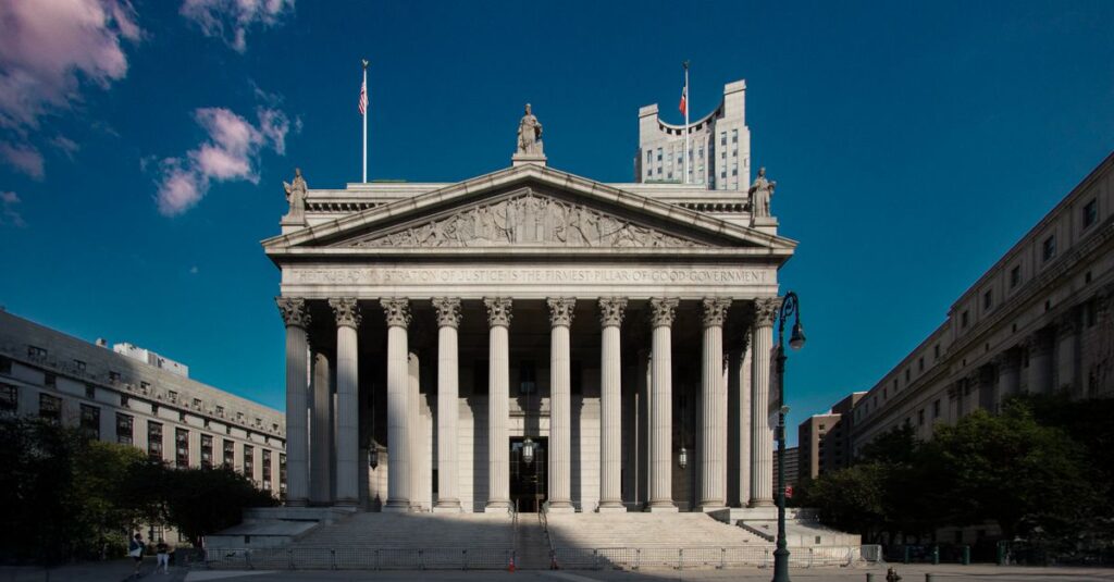 Front view of the Supreme Court building in New York City with blue skies.