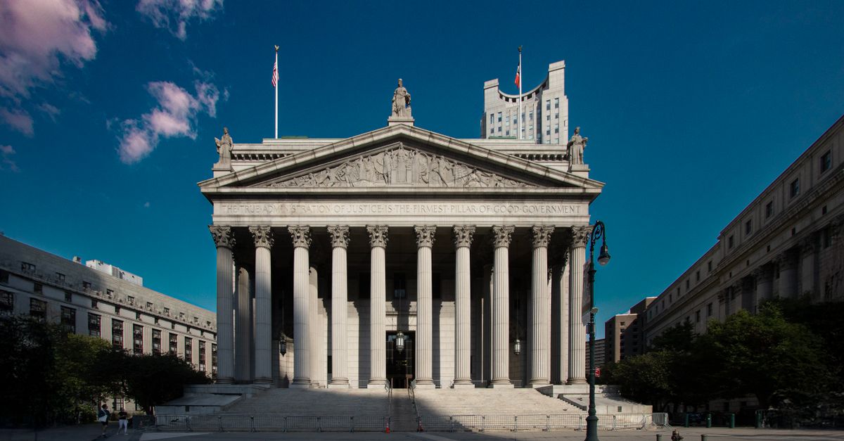 Front view of the Supreme Court building in New York City with blue skies.