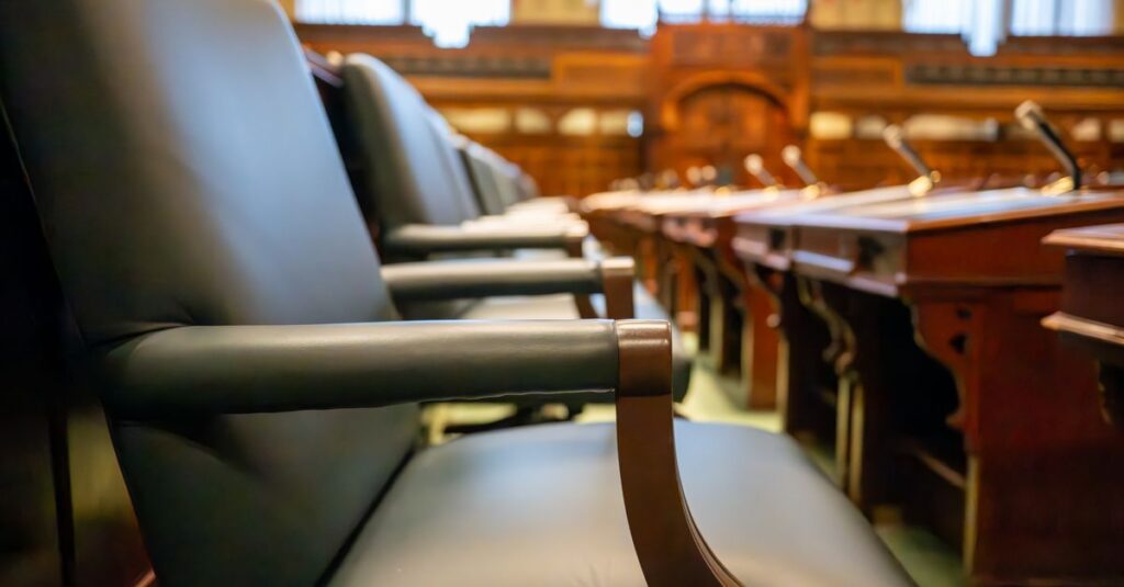 Elegant courtroom seating with leather chairs and wooden desks, exuding a sense of authority.