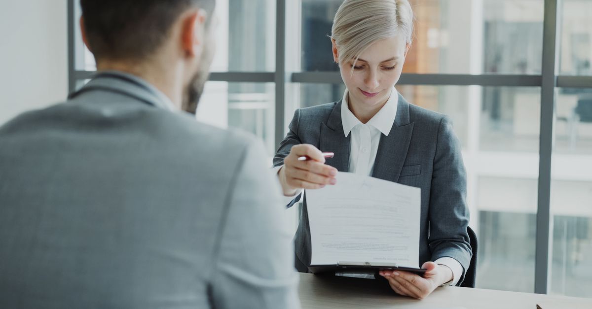 Business professionals reviewing a contract in a modern office setting.