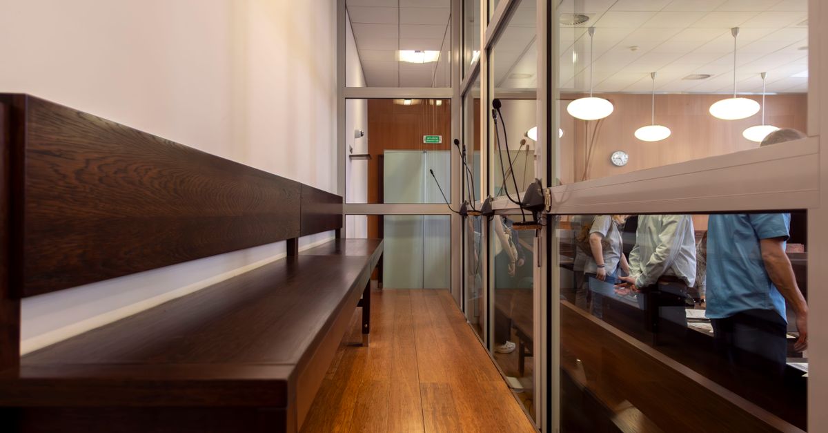 Interior view of a courtroom in Wrocław, Poland, featuring wooden benches and glass partitions.