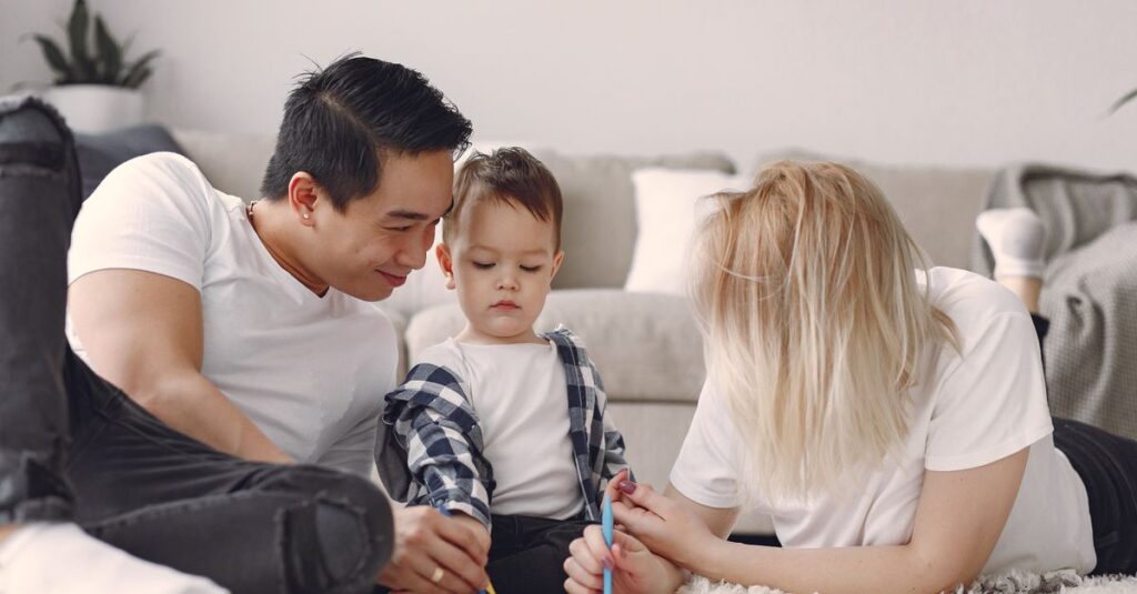Family enjoying quality time drawing together on the living room floor.