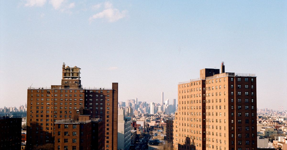 A scenic view of New York apartment buildings with a city skyline in the background.