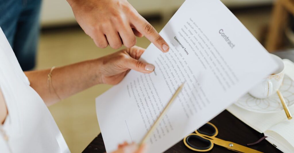Close-up of two people discussing a business contract at a desk in an office setting.