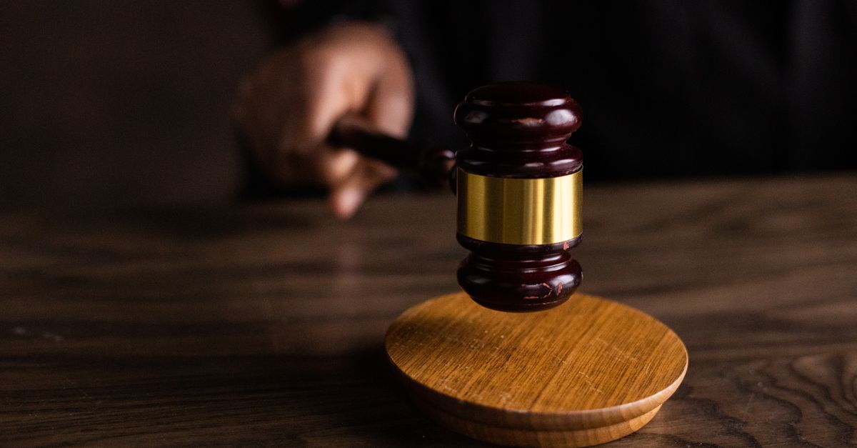 A gavel striking a sound block, symbolizing justice and legal authority in a courtroom setting.