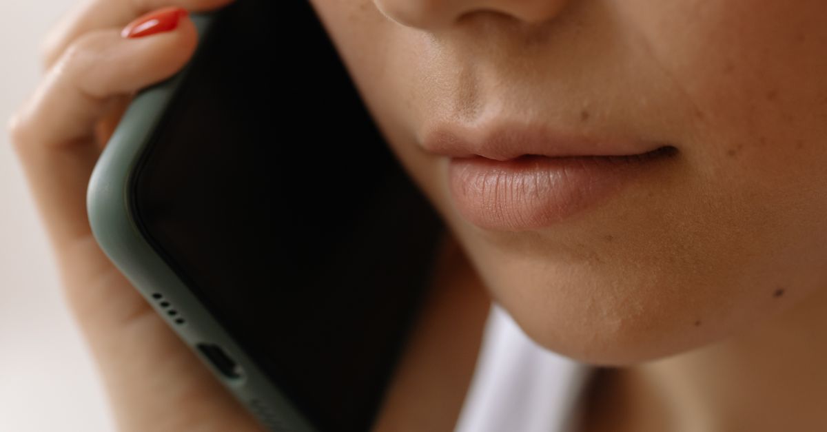 A close-up image of a woman holding a smartphone to her ear, emphasizing communication.