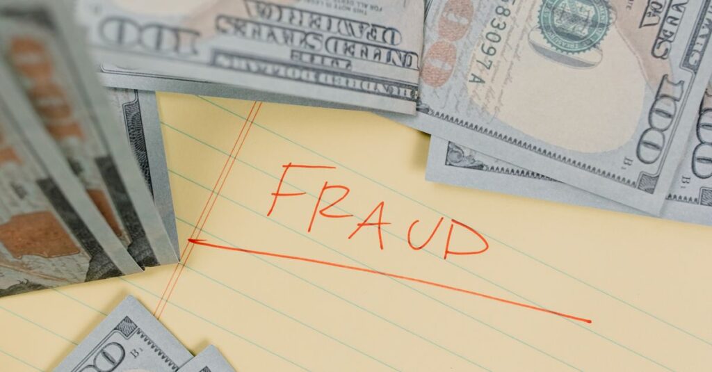 Close-up of US dollar bills on paper labeled 'FRAUD', highlighting financial deception.