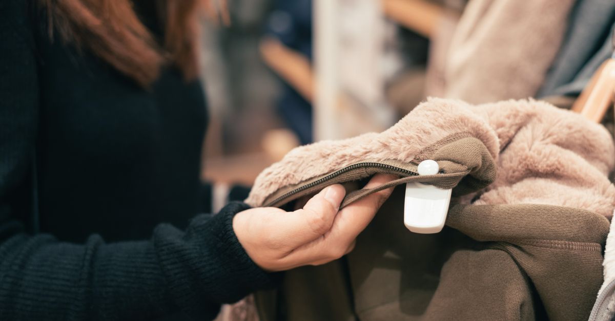 Close-up of a woman examining a coat in a clothing store, focused on texture and design.