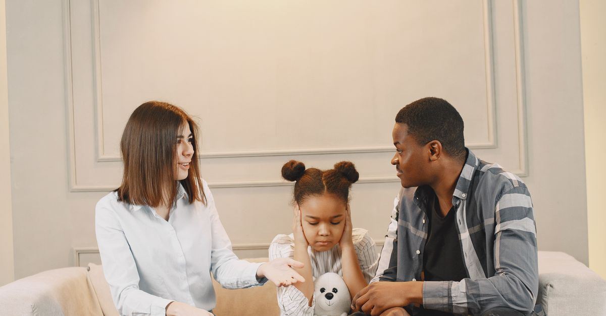 A family engaging in a thoughtful conversation while sitting on a stylish sofa in a modern living room.