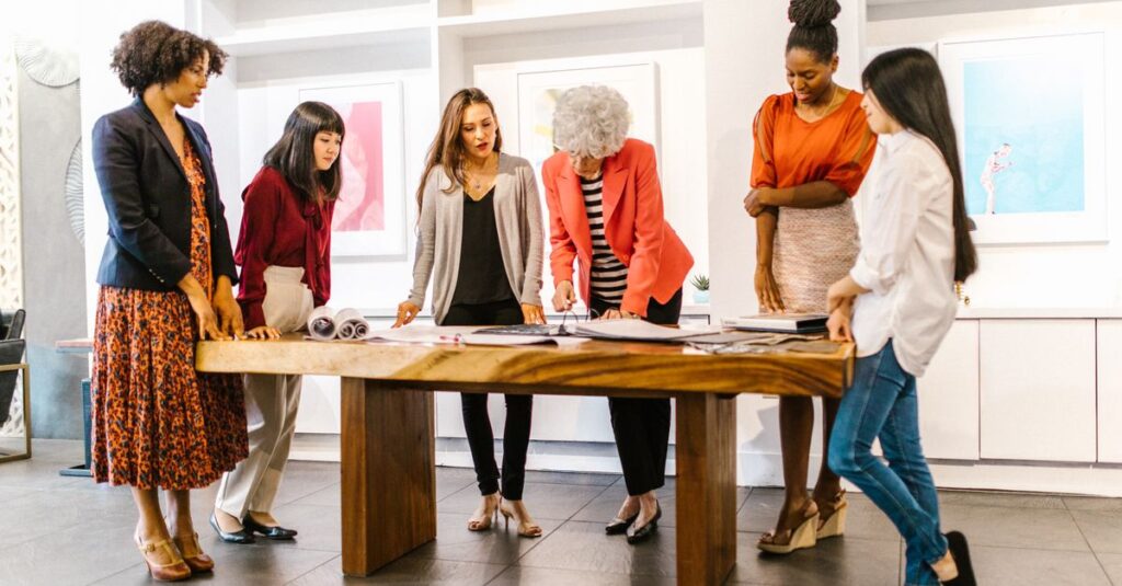A diverse group of women collaborating on a project in a modern office setting.