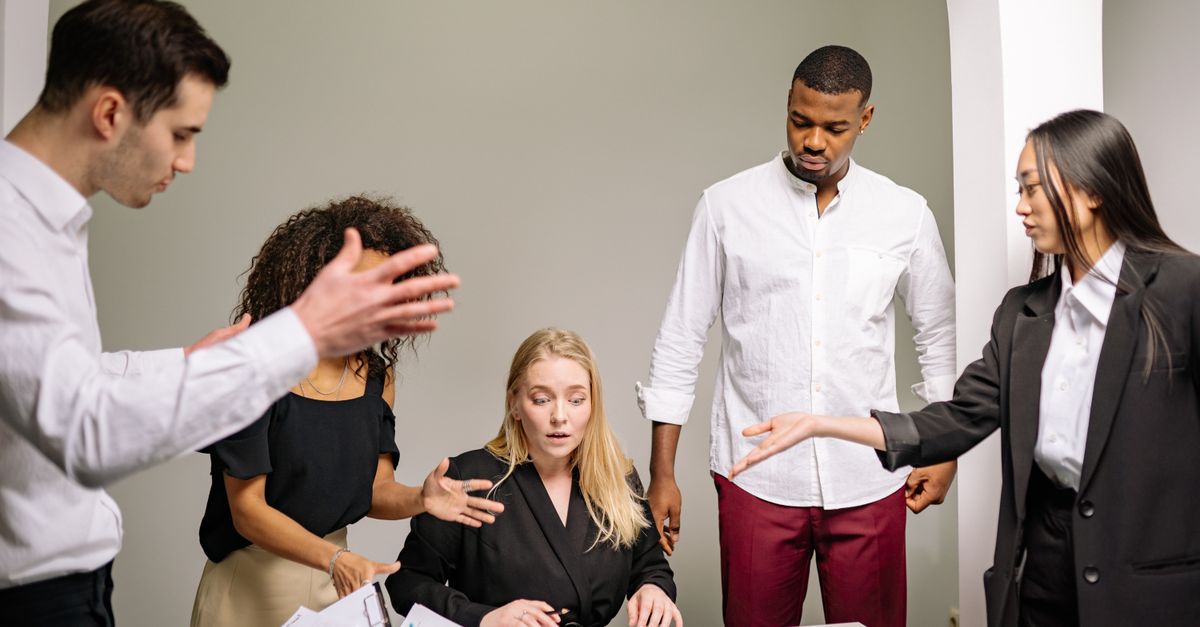 A diverse group of colleagues engaged in an intense discussion in an office setting.