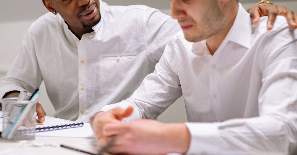Caring professional comforting a distressed coworker at the office.
