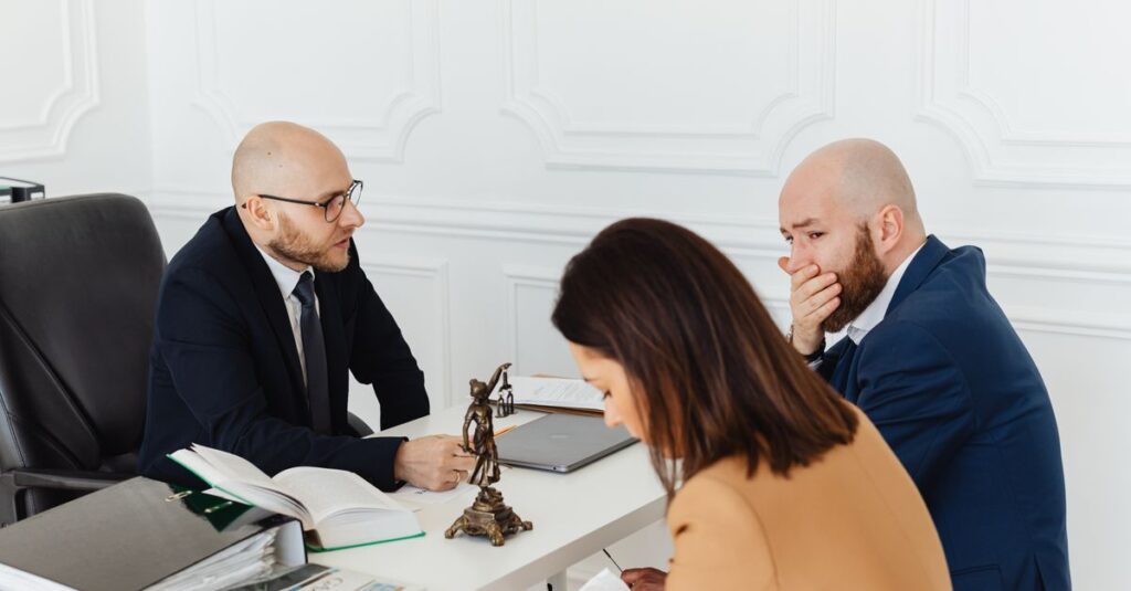 A serious legal consultation in a professional office environment involving three adults.