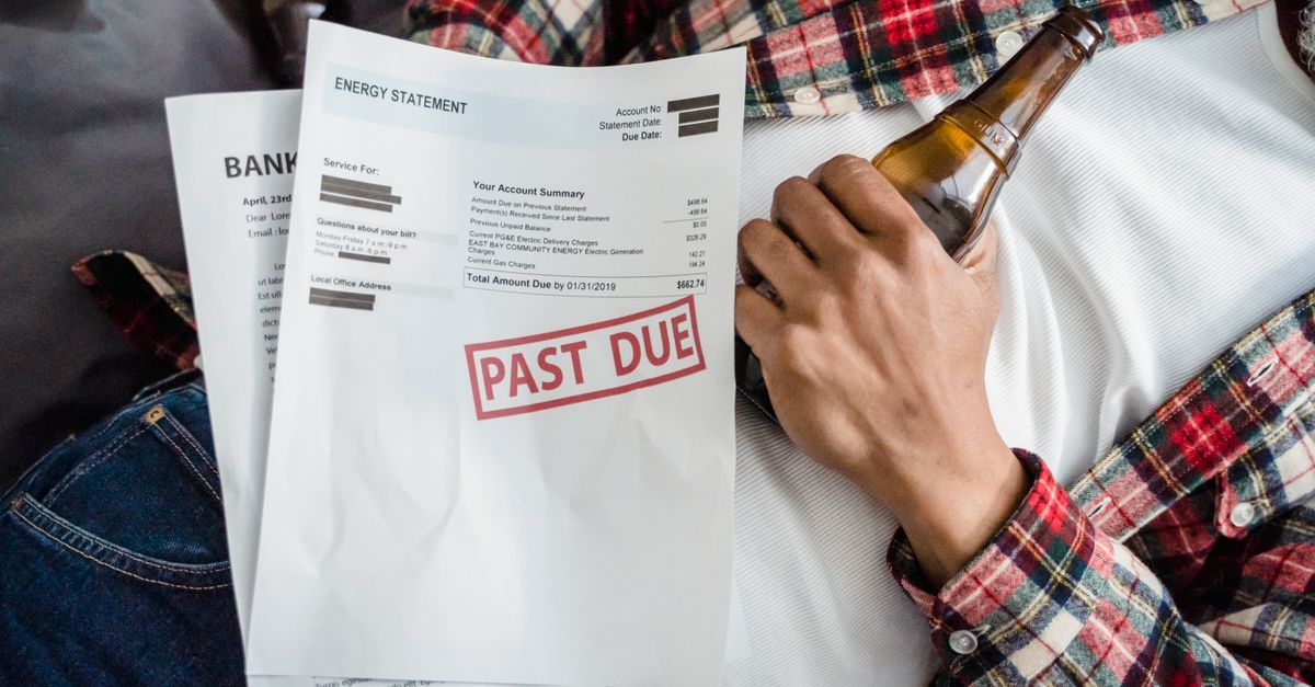 A man relaxes with a beer bottle while holding past due bills, highlighting financial stress.