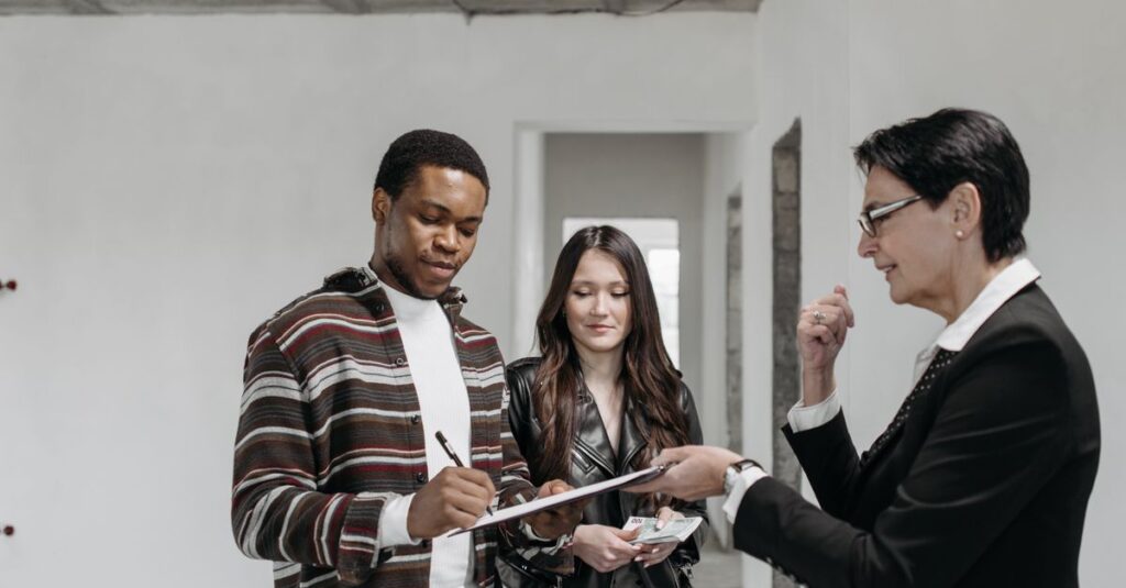 A diverse couple signing documents with a realtor in a new home setting.