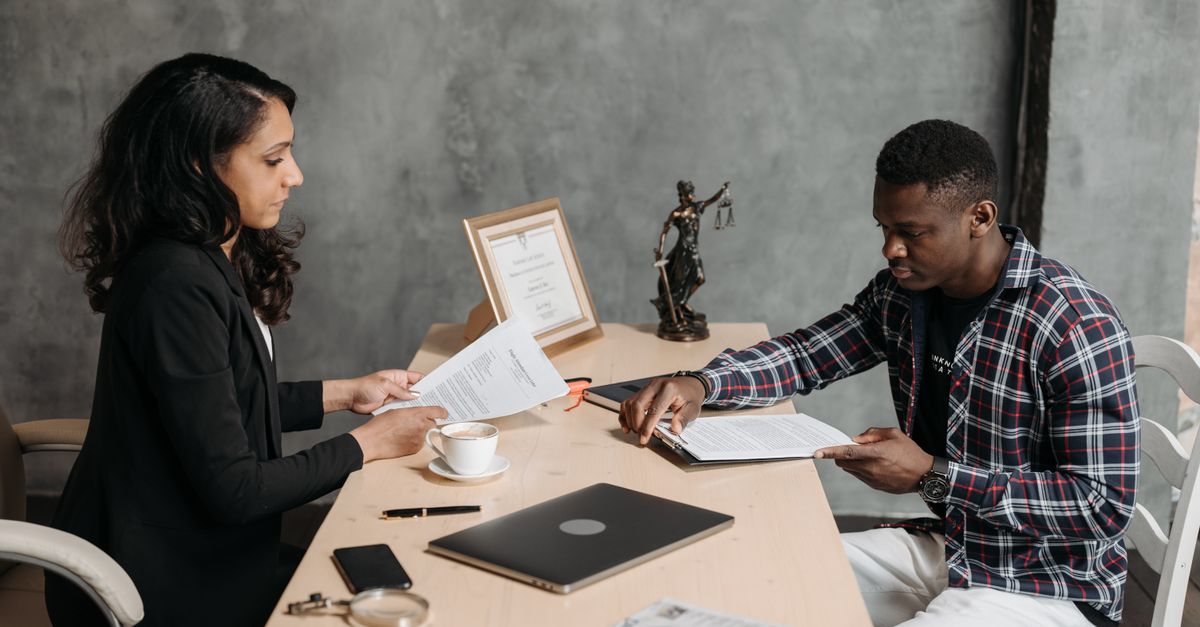 Business professionals discussing documents in a modern office setting.