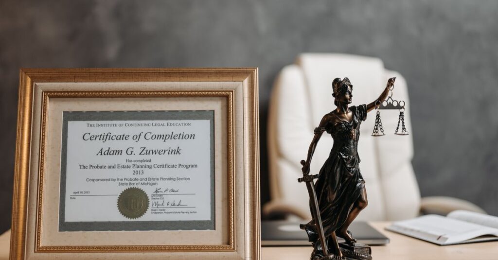 A framed legal certificate and Lady Justice figurine on a desk in a law office setting.