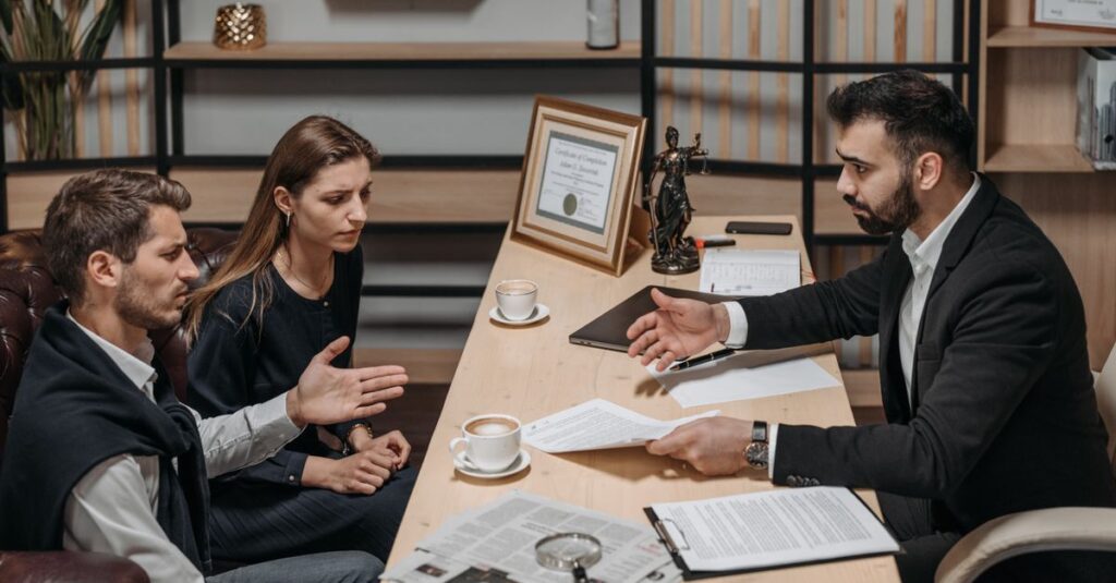 Lawyer consulting clients in an office. Documents and coffee on the table.