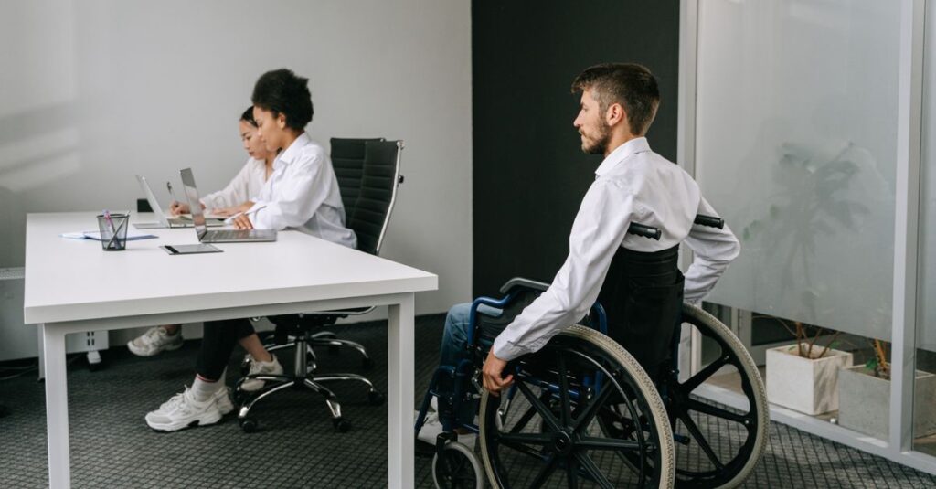 Diverse team in an office meeting, focusing on inclusive workplace and accessibility.