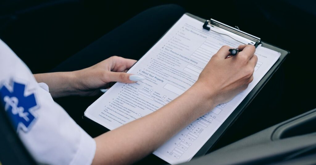Close-up of a paramedic taking notes on a clipboard in a car.