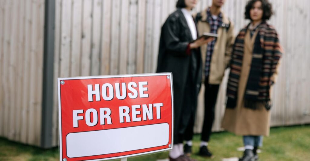 Three adults examining a house for rent sign outdoors, depicting diverse and inclusive interest in rental properties.