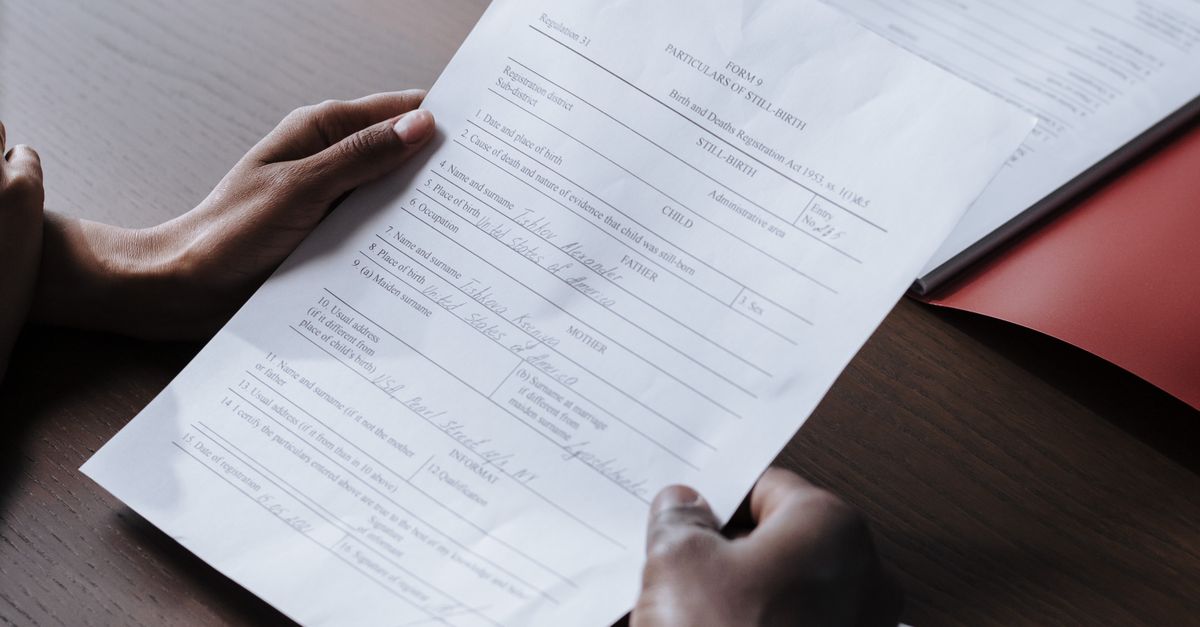 Adults reviewing legal documents on a wooden desk indoors, highlighting professional collaboration.