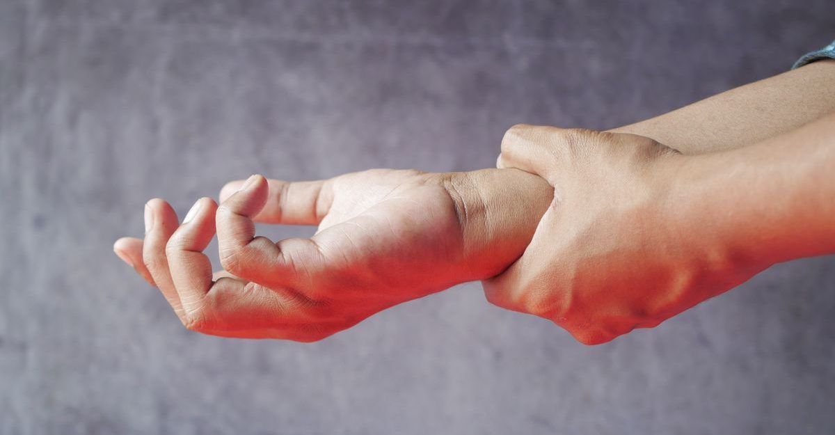 Close-up of hands, one grasping the other, symbolizing pain or discomfort.