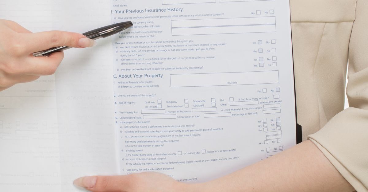 Close-up of a professional presenting insurance paperwork with a pen.